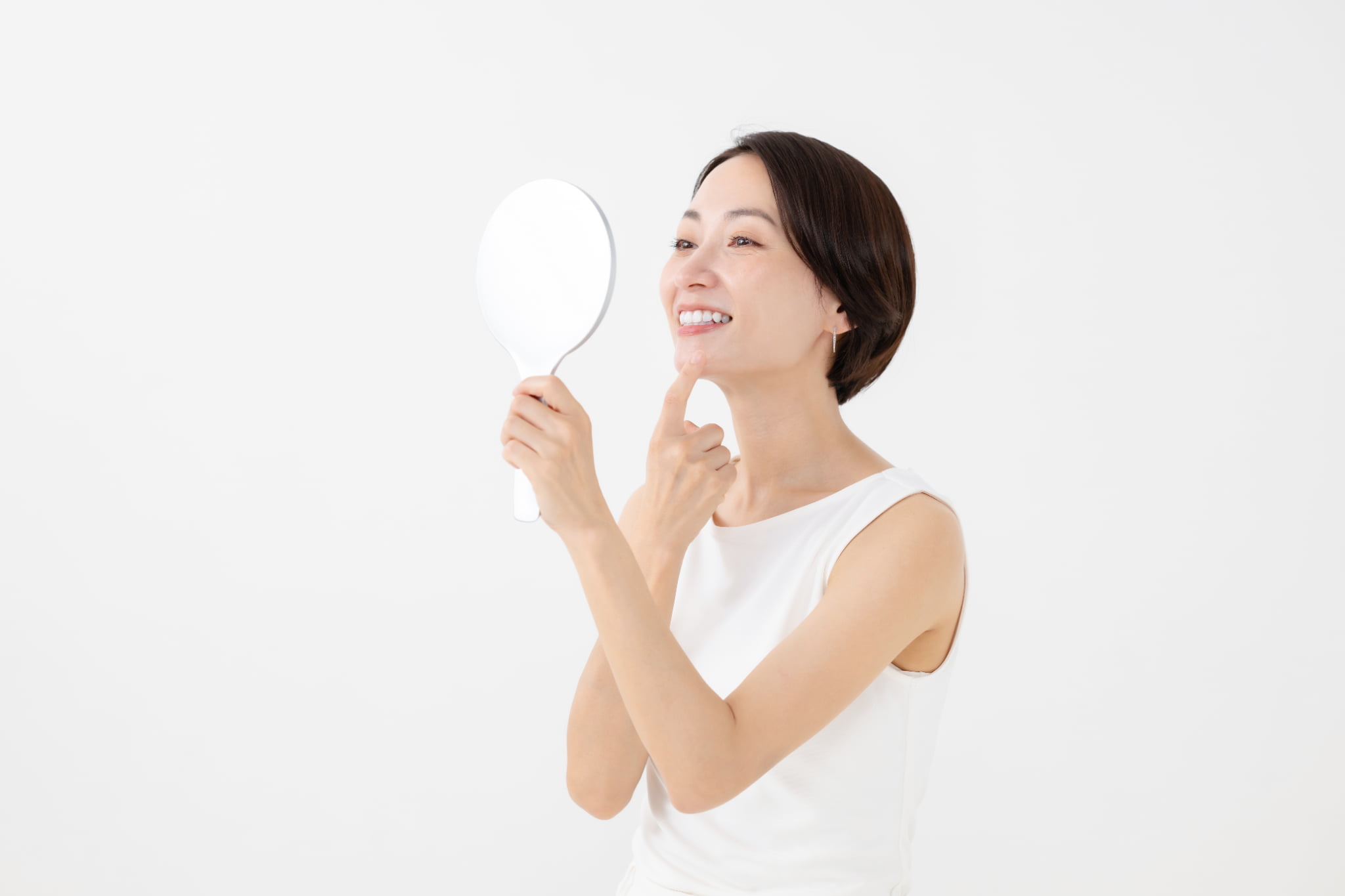 虫歯の初期症状を鏡でセルフチェックする女性