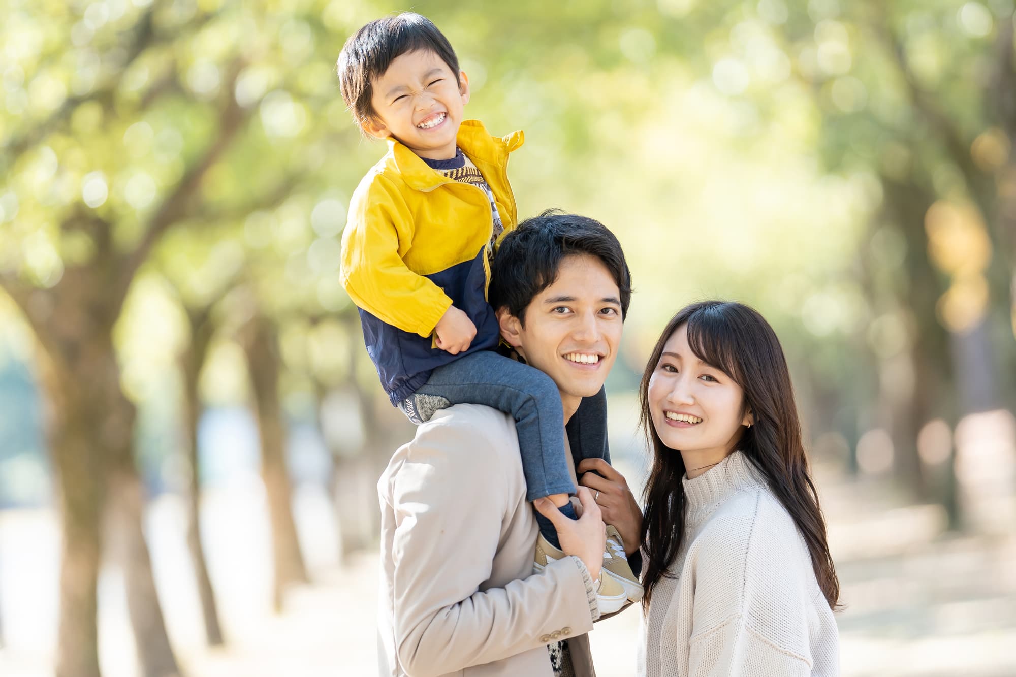 子どもを肩車して散歩する親子