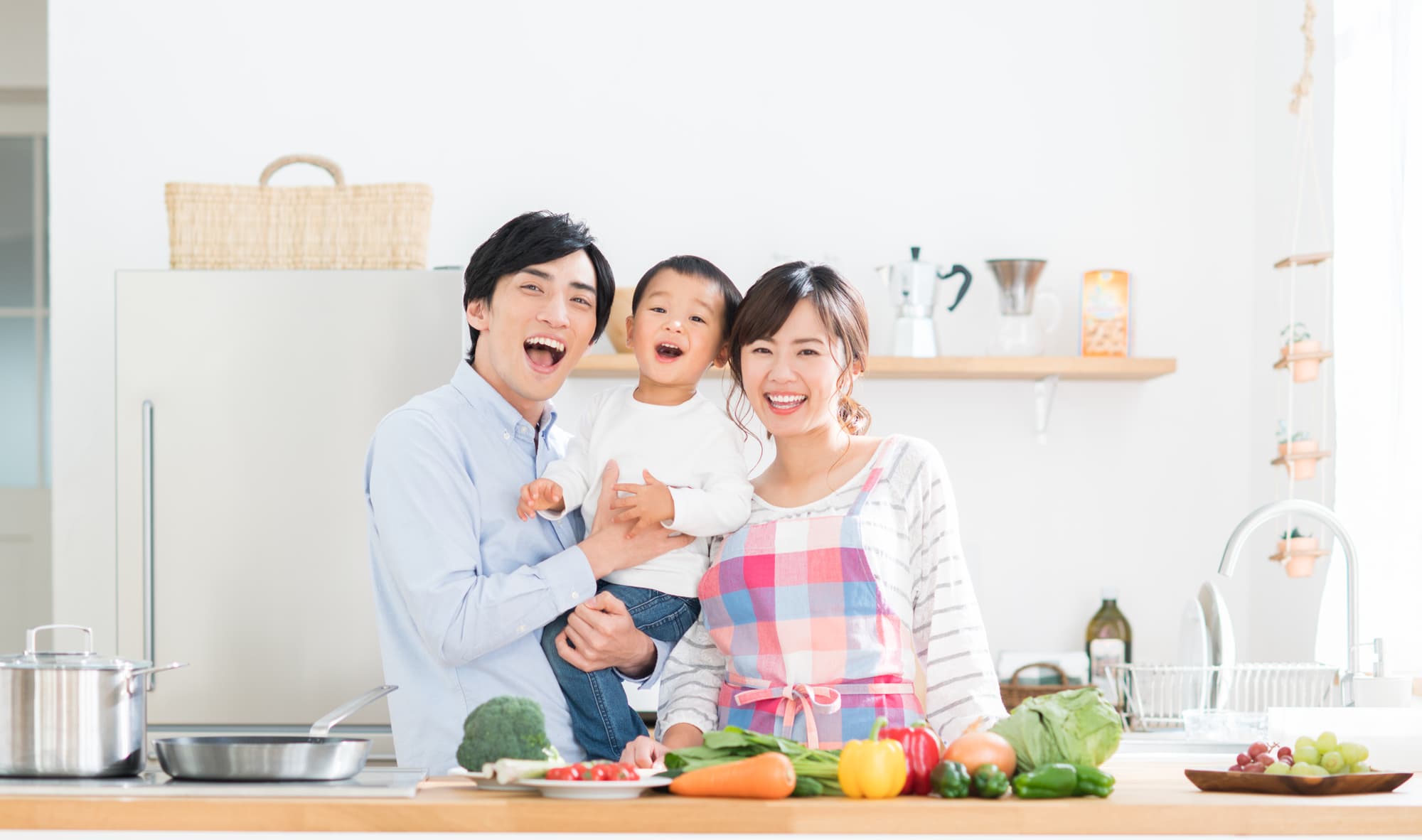 キッチンでたくさんの野菜と笑顔の親子