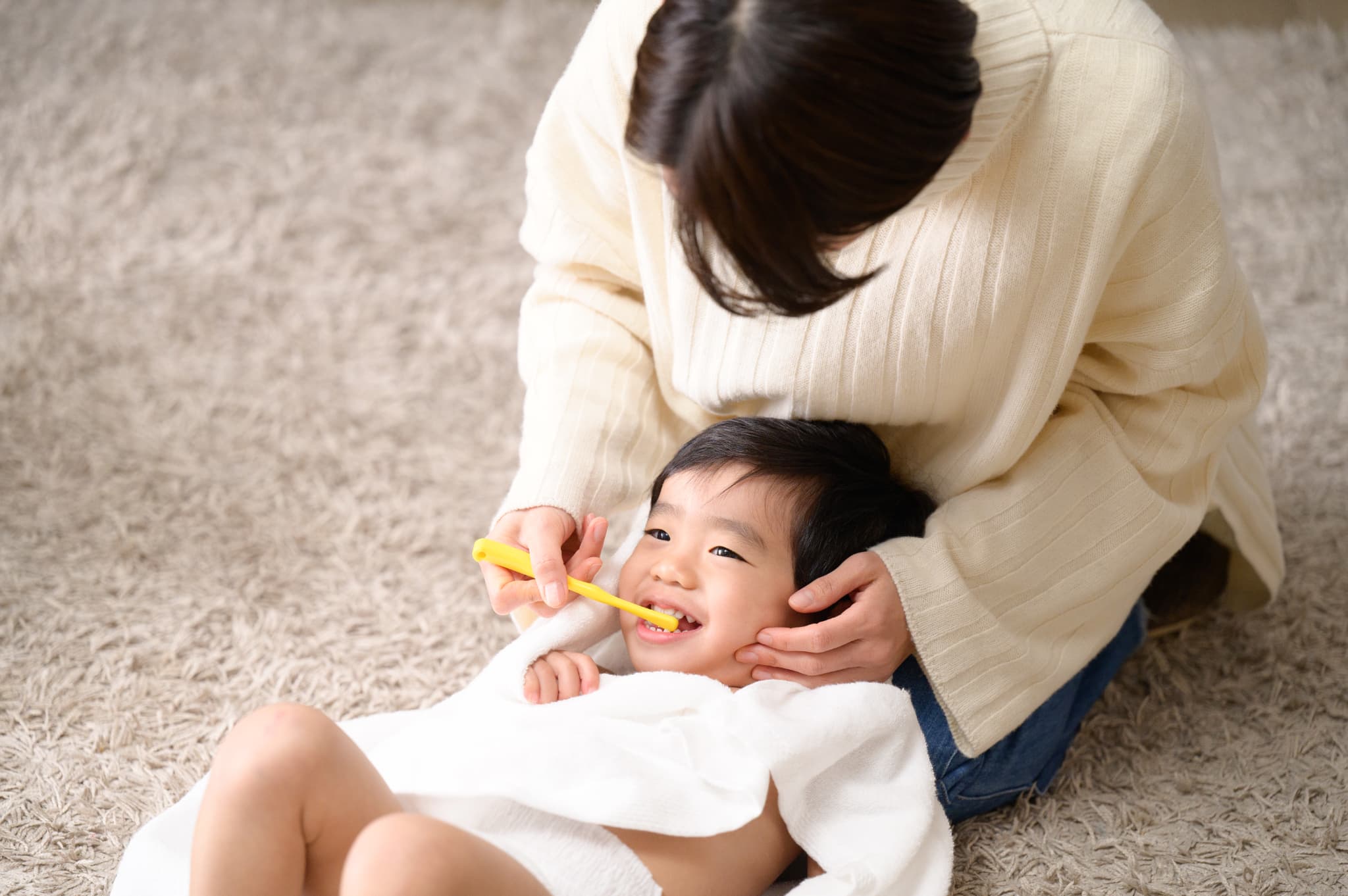 母親が子どもの歯磨きをする様子