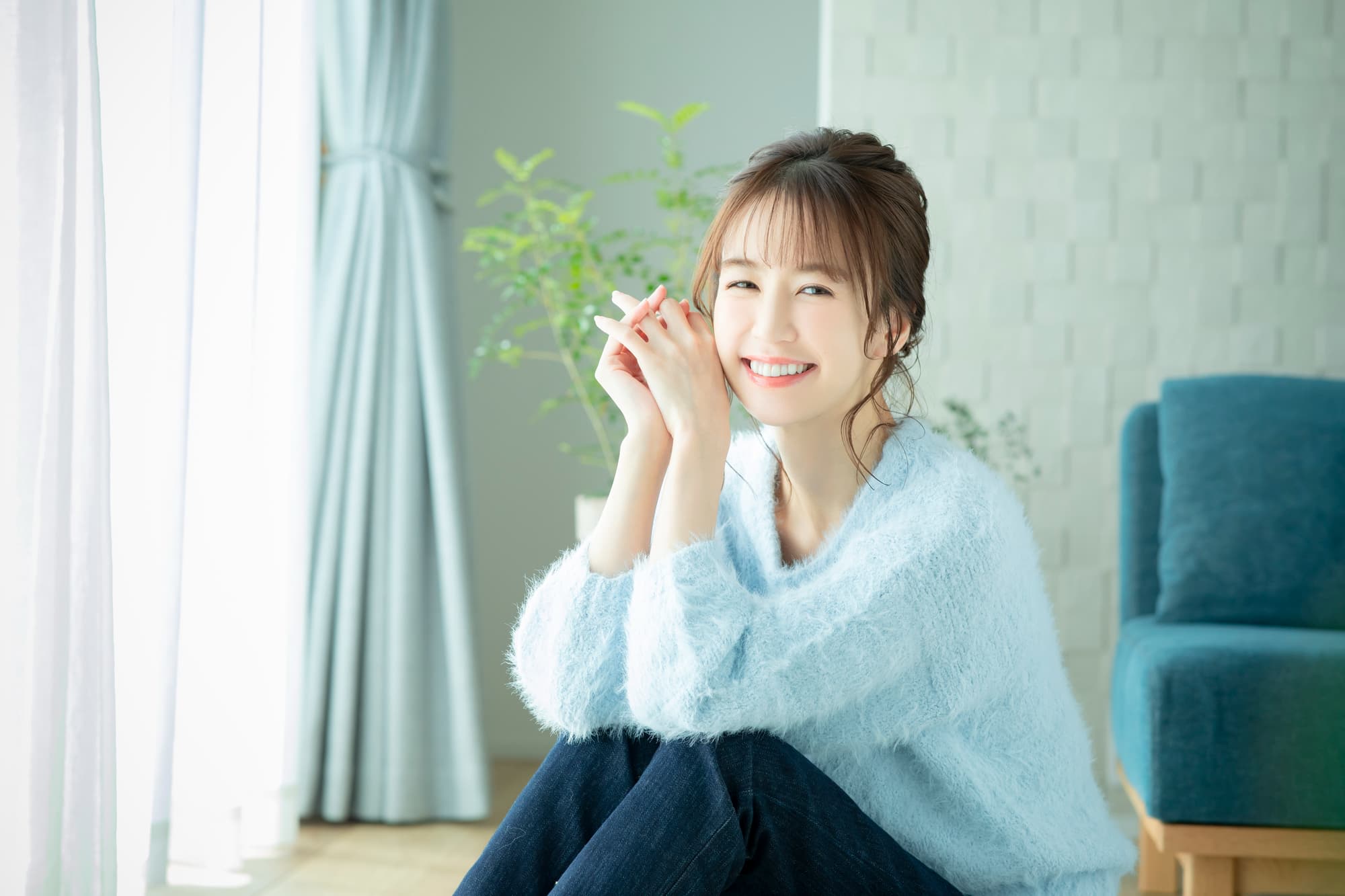 ワイヤー矯正で治した美しい歯の女性がリビングで寛いでいるイメージ