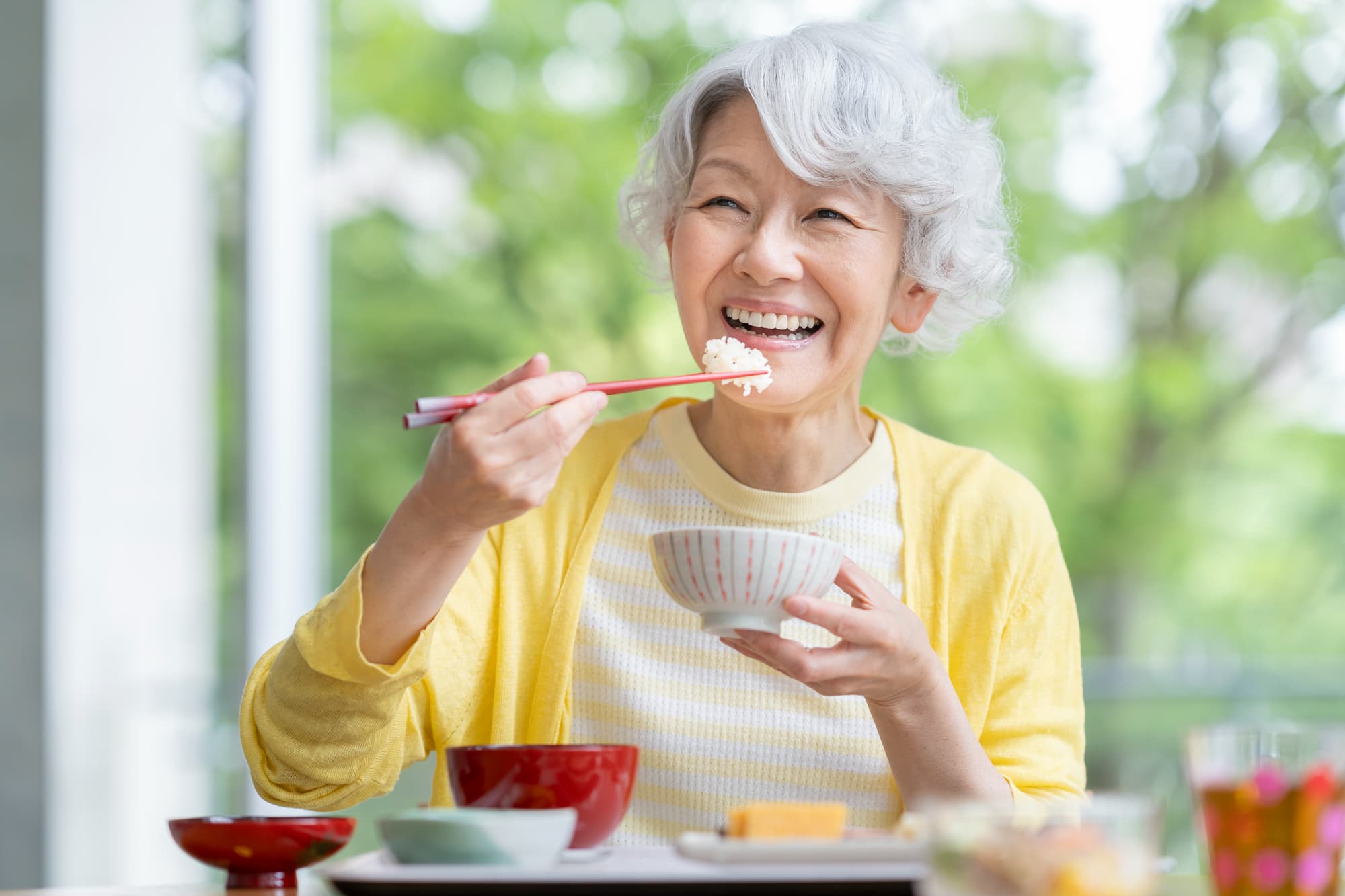 インプラント治療をして快適に食事をする女性