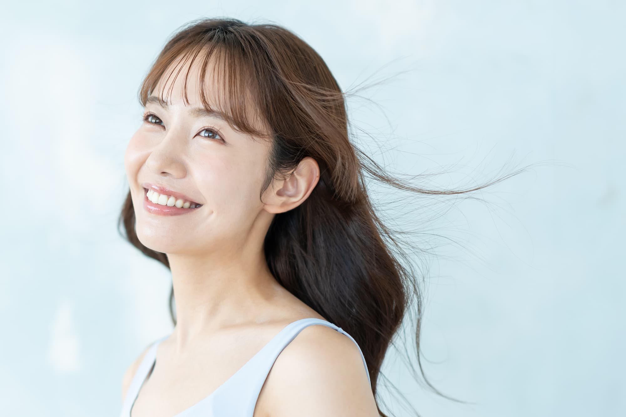 セラミックの美しい歯に満足して微笑む女性