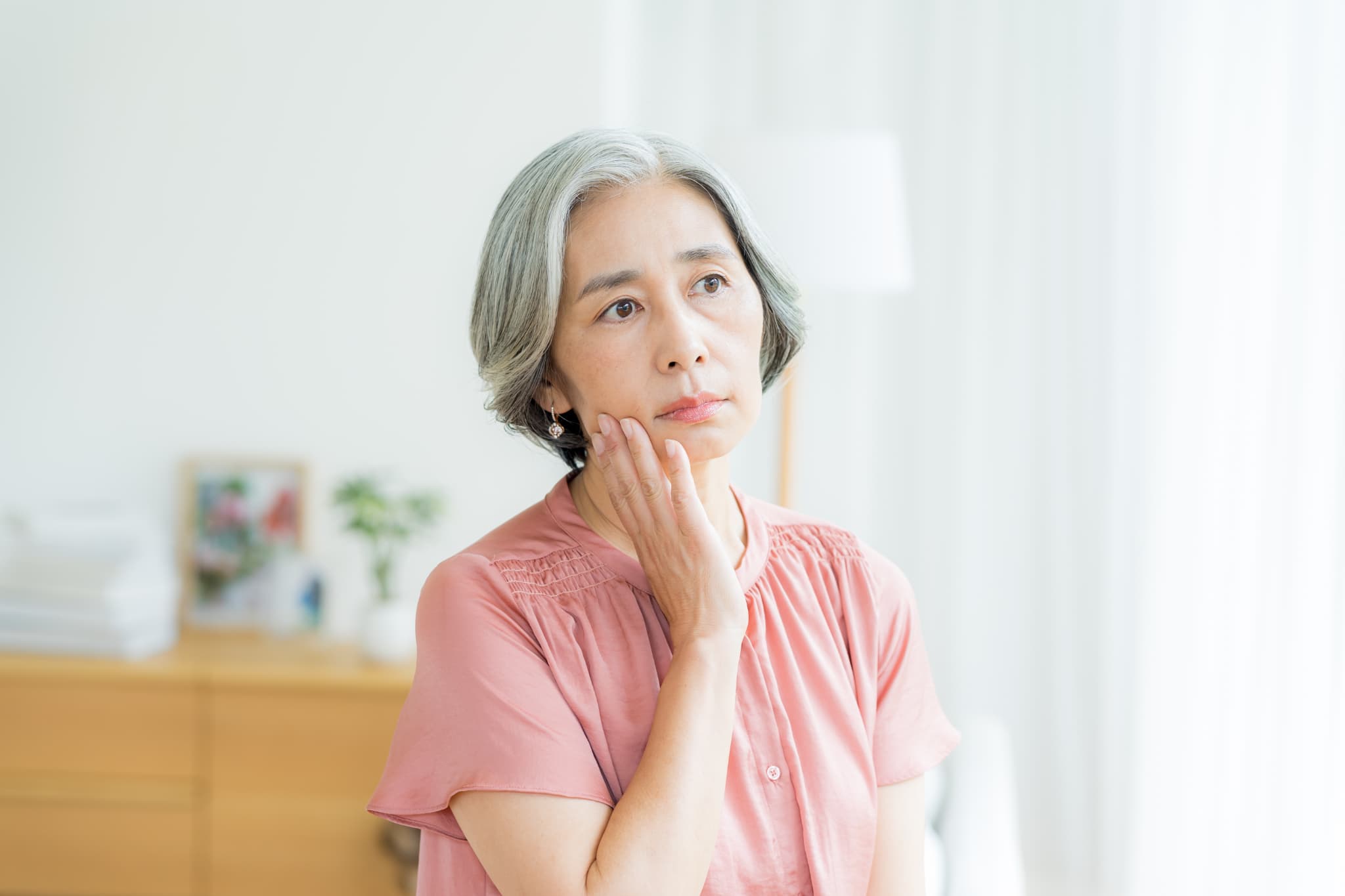 入れ歯とインプラント、どちらを選ぶのがいいのか悩む高齢女性