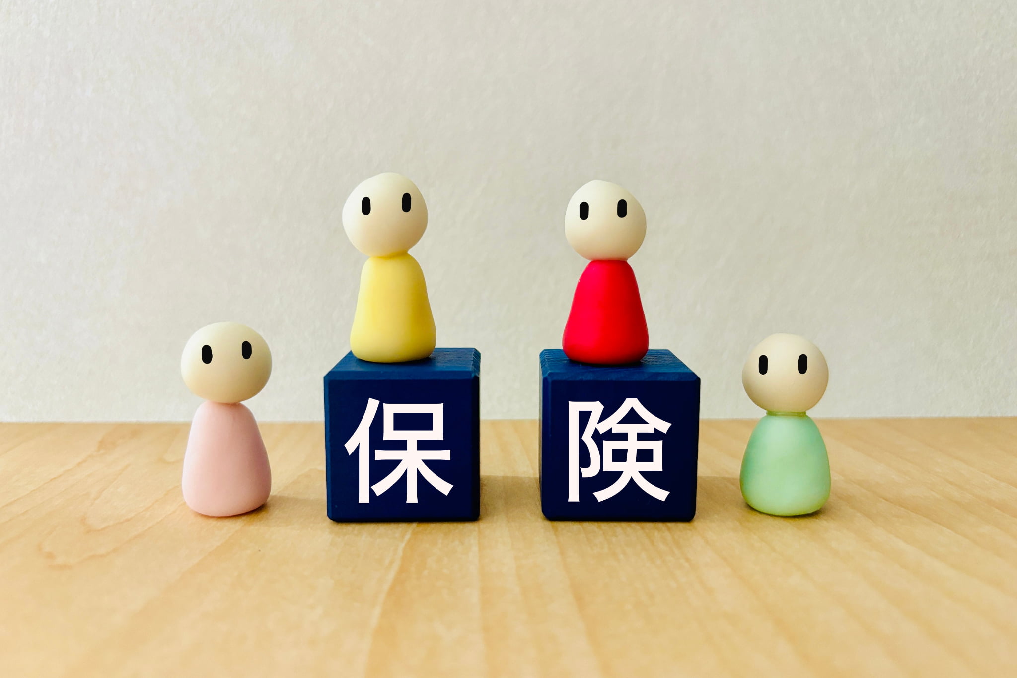 保険のブロックを囲む人形達